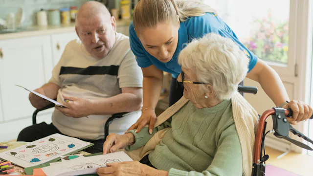 Caregiver assisting an elderly couple at home