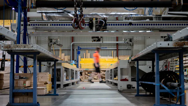 Worker walking through a factory floor with industrial machinery